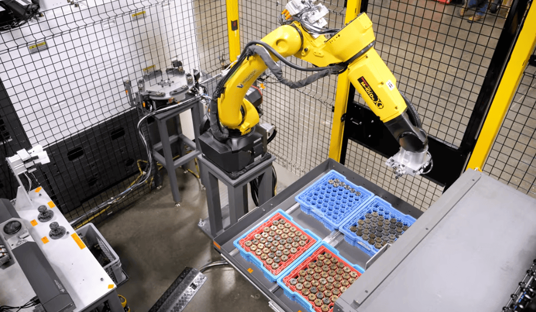 Industrial robot arm performing machine tending, interacting with workholding fixtures and parts in a manufacturing setting, emphasizing automation and efficiency.